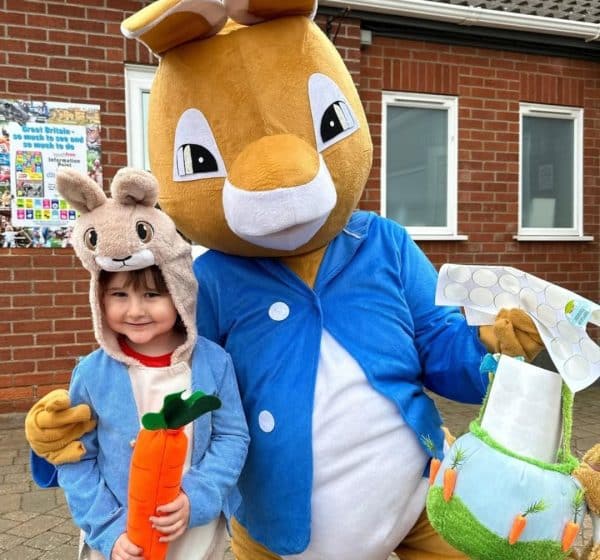 A child and adult dressed as Peter Rabbit pose for a photo at Pinewoods Holiday Park.