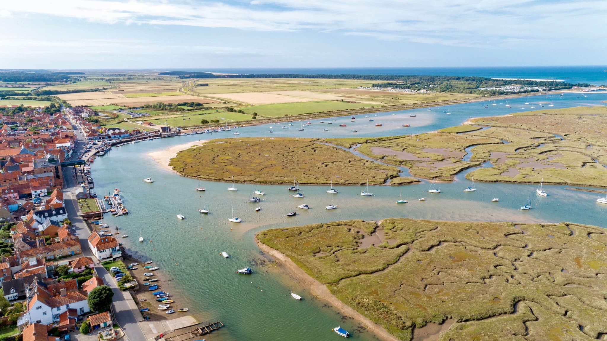 Aerial shot showing Wells Town, the quay where you can go crabbing, Pinewoods Holiday Park, Holkham National Nature Reserve and Wells Beach.